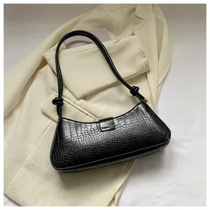 Close-up of black crocodile-embossed leather texture on a sleek French baguette bag