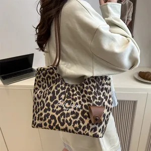 Large leopard print suede tote bag with brown shoulder straps and mini charm accessory