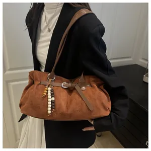 Detail der braunen Wildleder-Schultertasche mit Retro-Holzperlen und Schnallenakzent