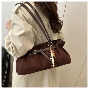 Nahaufnahme der braunen Vintage-Wildledertasche mit Perlenanhänger und Metallschnalle