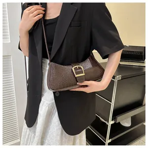 Close-up of dark brown crocodile pattern underarm bag with gold metal buckle