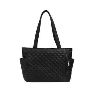 Minimalist black quilted tote bag with diamond pattern and long handles for women