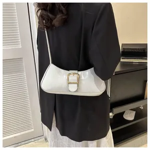 Close-up of white crocodile texture underarm bag with elegant golden square buckle detail