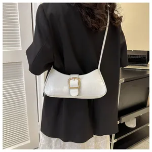 Detailed close-up of white crocodile pattern shoulder bag featuring a gold square buckle