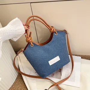 Vue détaillée d'un sac en denim bicolore avec poignée nouée et étiquette logo
