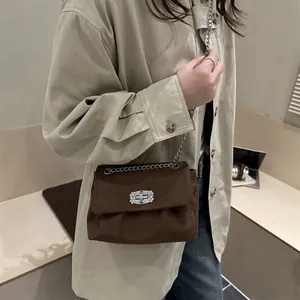 Brown suede crossbody bag with elegant diamond-encrusted lock and silver chain strap