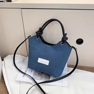 Sac à bandoulière rétro en denim avec anses en cuir noir nouées et logo mode