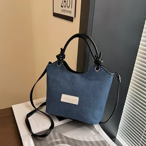 Sac fourre-tout rétro en denim bleu avec anses en cuir noir et bandoulière réglable