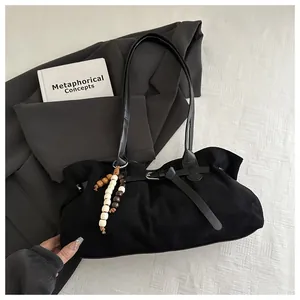 Sac fourre-tout rétro en daim noir avec perles en bois décoratives sur fond élégant