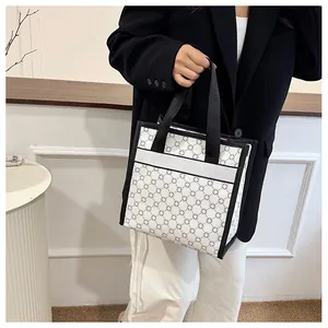 Close-up of printed tote bag featuring geometric cross patterns and black canvas handles
