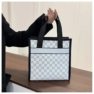Detailed macro view of black floral print on white canvas tote bag with reinforced straps