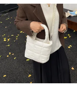 White quilted puffer tote bag shown in a lifestyle street setting with autumn leaves