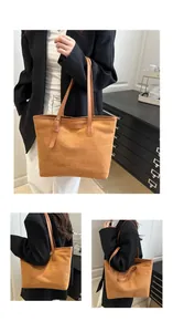Macro detail of tan suede tote bag featuring slim leather straps and vintage buckle