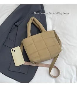 Quilted khaki tote bag showing size comparison with a smartphone on white fabric