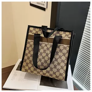 Detail of vintage tote bag with M-pattern print and sturdy black ribbon handles