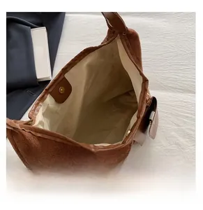 Dettaglio della grande borsa tote in pelle scamosciata marrone con chiusura magnetica