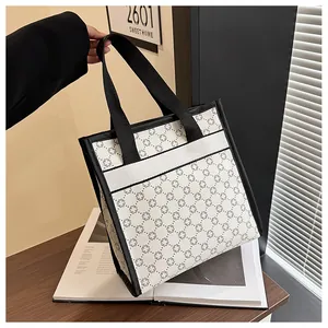Detail of printed tote bag with black geometric patterns and reinforced black handles