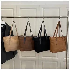 Set of suede tote bags in beige, dark brown, black, and tan hanging on a metal rack