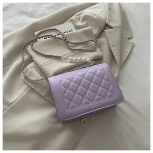 Detail der hellvioletten Stepptasche mit Goldkette und großen dekorativen Perlenverzierung