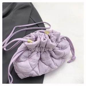 Detail of light purple quilted bucket bag featuring a soft puff texture and drawstring closure