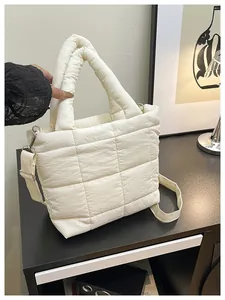 Detail of off-white quilted tote bag with cross-stitch pattern and detachable shoulder strap