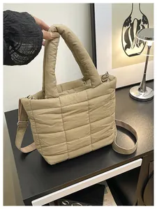 Detail of khaki quilted nylon tote bag featuring adjustable strap and soft puffer texture