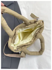 Inside view of beige quilted tote bag showing lining, pockets and detachable strap