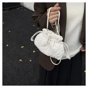 Detailed close-up of quilted drawstring cloud bucket bag in white with drawstring details