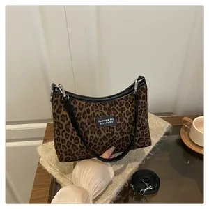 Dettaglio della borsa tote leopardata alla moda con manici in pelle PU nera e finiture