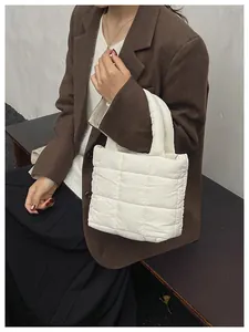 Detail of white quilted puffy handbag with square stitching and soft padded texture
