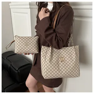 Detail of a beige monogram tote bag set with golden hardware and leather chain straps