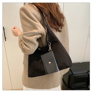 Dettaglio della borsa tote nera in camoscio con astuccio e finiture metalliche oro