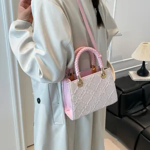 Pink woven handle satchel bag shown by a model in a modern indoor setting