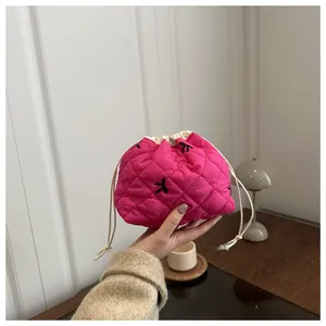 Nahaufnahme der rosafarbenen gesteppten Beuteltasche mit Stickerei und Kordelzug