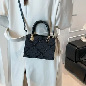 Chic black woven textured crossbody bag with gold hardware and stylish braided handles