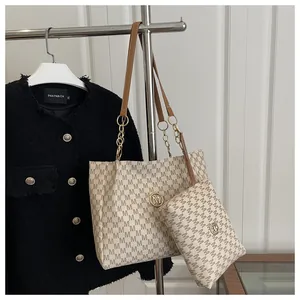 Dettaglio della borsa shopper beige monogramma con spalline in pelle marrone e catena