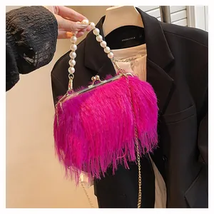 Dettaglio borsa peluche rosa acceso con manico di perle e cornice in metallo oro
