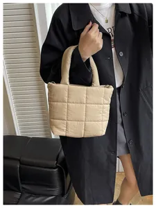 Close-up of beige quilted tote bag showing large square padding and soft fabric texture