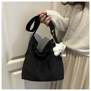 Detail of black nylon tote bag with drawstring, wide strap and cute cloud charm