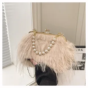 Dettaglio della borsa da sera in ecopelliccia beige con manico di perle e catena d'oro