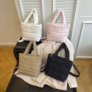 Minimalist quilted tote bag set in white pink khaki and black shown on a leather bench