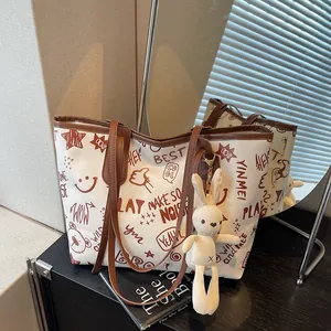 Graffiti canvas tote bag with star patterns and plush bunny charm on black counter