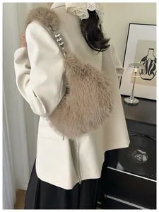 Detail of light brown faux fur crossbody bag with heart shaped metal chain and soft texture