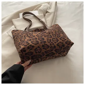 Detail einer großen Tragetasche mit Leopardenmuster und braunen Riemen auf einem Blazer