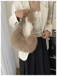 Detail of fluffy brown crescent bag with plush handle and heart charm metal chain