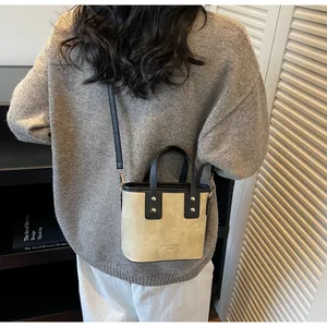 Detail shot of mini bucket bag with contrast trim on a model showing practical usage