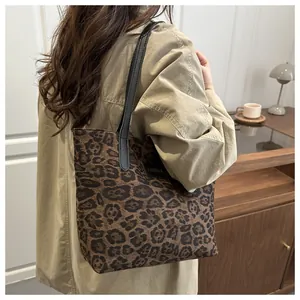 Detailansicht der großen Shopper-Tasche mit Leopardenmuster, schwarzem Gurt und Mode-Etikett