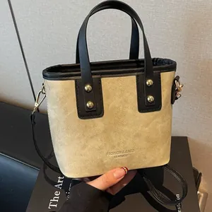 Retro contrast bucket bag in beige and black leather with golden rivets and strap