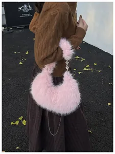 Detail of pink faux fur crescent bag with silver chain strap shown in outdoor setting