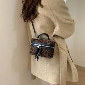 Sac à main tendance imprimé léopard avec lanières en cuir noir et détails de pompons